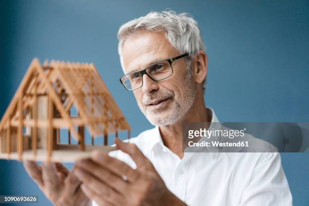 successful architect looking at model of a house - shirt mockup stock pictures, royalty-free photos & images