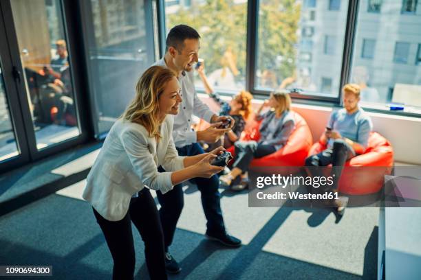 colleagues playing video game in office - panel gaming art or commerce stockfoto's en -beelden