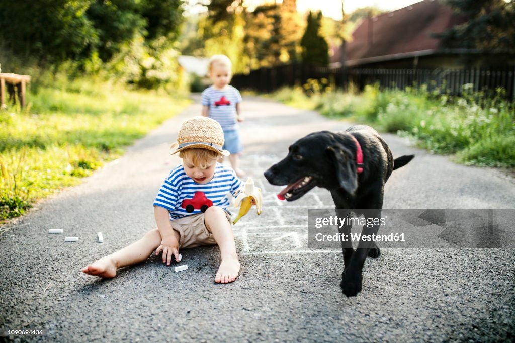 Toddler boy playing with chalks on the street