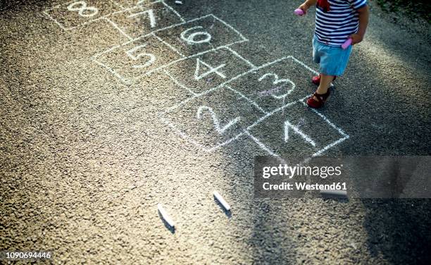 little girl with drawn hopscotch on the street, partial view - hopscotch stock pictures, royalty-free photos & images