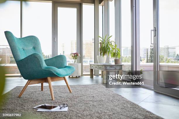 home interior with armchair, tablet and view on roof terrace - french doors stockfoto's en -beelden