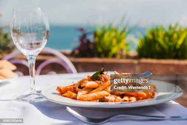 italy, atrani, plate of penne rigate with tomato sauce and tuna - tomatensoße stock-fotos und bilder