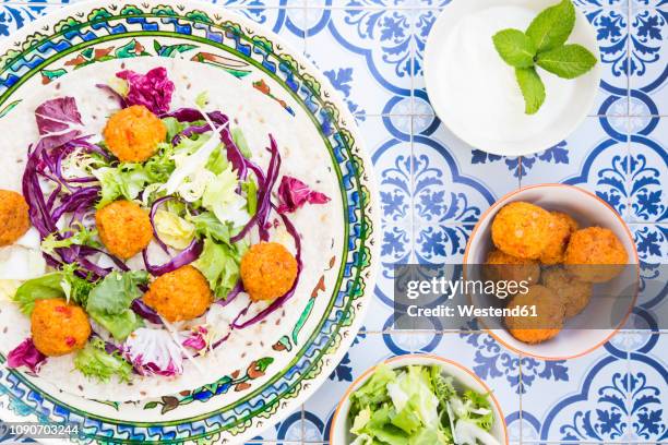 falafel, leaf salad, red and white cabbage and yogurt sauce with mint on wrap - faláfel fotografías e imágenes de stock