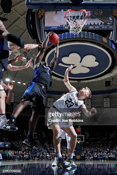 Zion Williamson of the Duke Blue Devils rebounds over Dane Goodwin of the Notre Dame Fighting Irish in the second half of the game at Purcell...