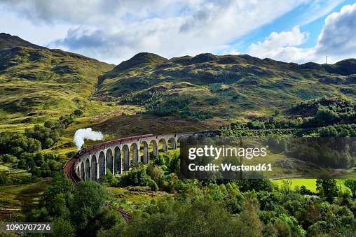 UK, Scotland, Highlands, Glenfinnan viaduct with a steam train passing over it UK, Scotland, Highlands, Glenfinnan viaduct with a steam train passing over it