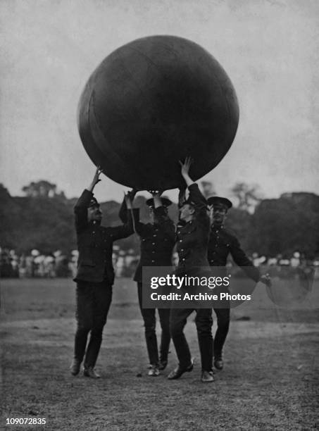 British cavalrymen bringing in a pushball, used in an equestrian version of the game, at a polo meeting and cavalry display at the Hurlingham Club in...