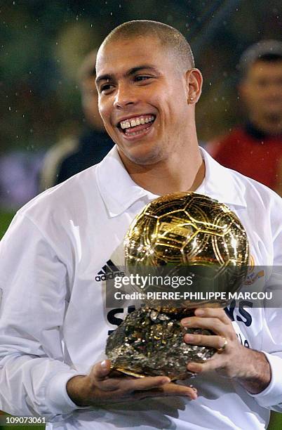 Brazilian player Ronaldo holds the Golden Ball trophy offered by "France Football" before the Real Madrid Centenary match beetwen Real Madrid and...