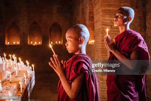 myanmar-novizen an buddha-statue beten - pagan stock-fotos und bilder