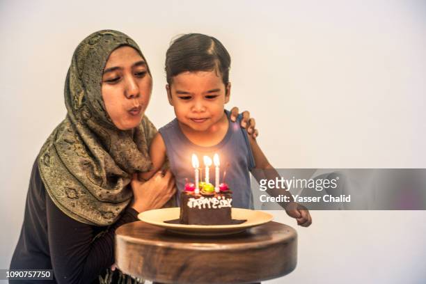 Mother and son blowing candle