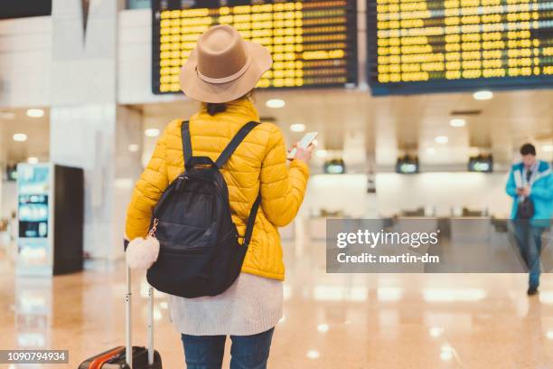 girl at the airport checking the arrival departure board - aeroporto de heathrow imagens e fotografias de stock