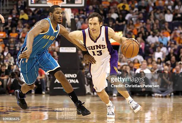 Steve Nash of the Phoenix Suns drives the ball past Trevor Ariza of the New Orleans Hornets during the NBA game at US Airways Center on January 30,...