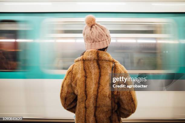 vrouw te wachten op het metrostation in parijs - subway paris stockfoto's en -beelden