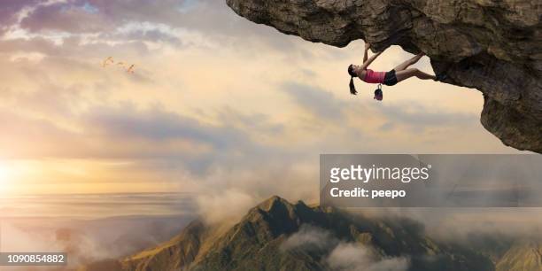 mujer libre escalador sube proyección por encima de las montañas al amanecer - alto posición descriptiva fotografías e imágenes de stock