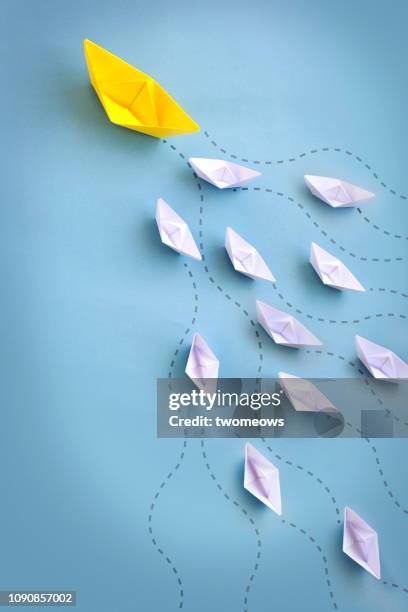 conceptual leadership paper origami boat still life. - origami boat stock pictures, royalty-free photos & images