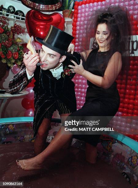 David Gakshteyn drinks melted chocolate from the shoe of his new wife Cleo Londono after the two were married on Valentines Day while standing in a...