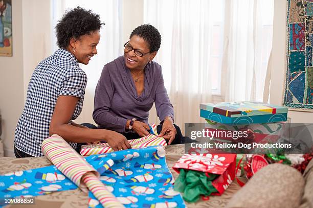 mom and adult doughter wrapping christmas presents - mother and daughter making the bed stock pictures, royalty-free photos & images