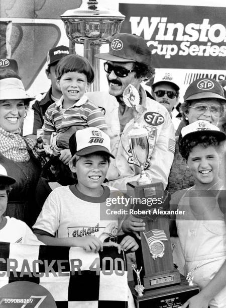 Richard Petty, driver of the STP Pontiac, celebrates in Victory Lane at the Daytona International Speedway after winning the 1984 Firecracker 400 on...