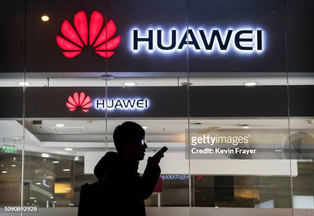 Pedestrian talks on the phone while walking past a Huawei Technologies Co. Store on January 29, 2019 in Beijing, China. The U.S. Justice Department...