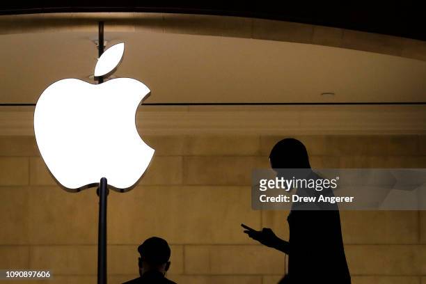 Man checks his phone in an Apple retail store in Grand Central Terminal, January 29, 2019 in New York City. Apple is set to report first-quarter...