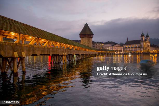 The Chapel Bridge or Kapellbrucke at Lake Lucerne and Water Tower at night on December 30, 2018 in Lucerne, Switzerland. The Kapellbruecke or Chapel...