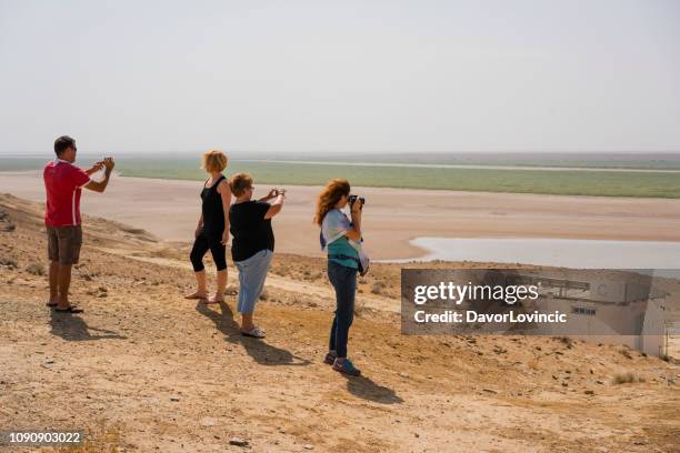 turista olhar o deserto de kara kum no turquemenistão lado uzbeque entre khiva e bokhara no uzbequistão. - turkmenistan - fotografias e filmes do acervo