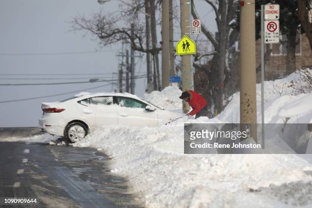 Man tries to get his car out on Warden just north of Danforth rd. Nasty cold and snowy conditions made a mess of the morning commute.