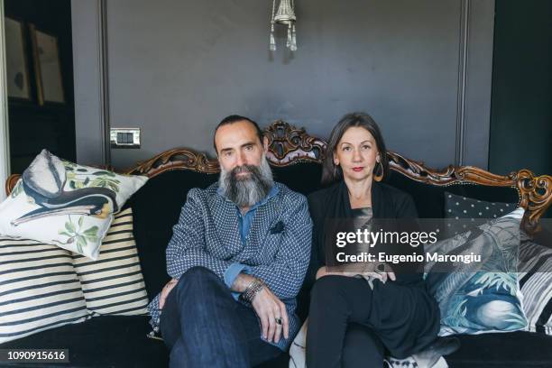 couple sitting on antique sofa - antique sofa styles foto e immagini stock