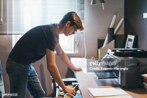 man working in home office - printer fotografías e imágenes de stock