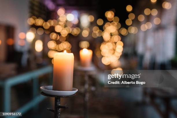 close up of lit candle in cafe with decorative lights - vintage restaurant ストックフォトと画像