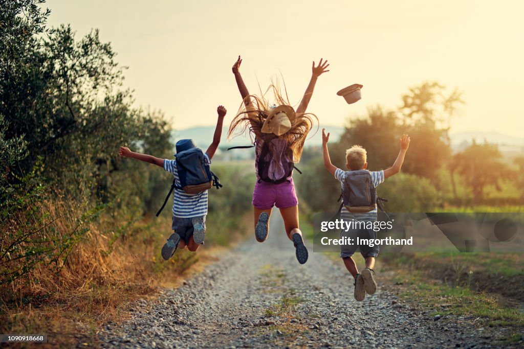 Happy little hikers jumping with joy