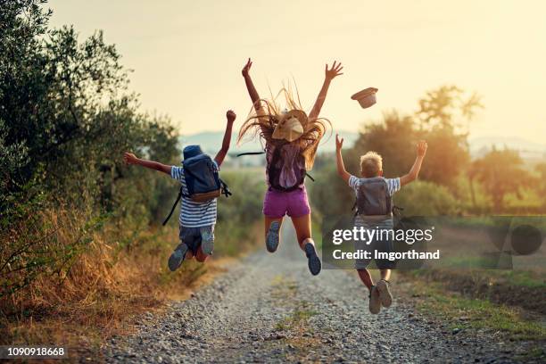 happy little hikers jumping with joy - criança imagens e fotografias de stock