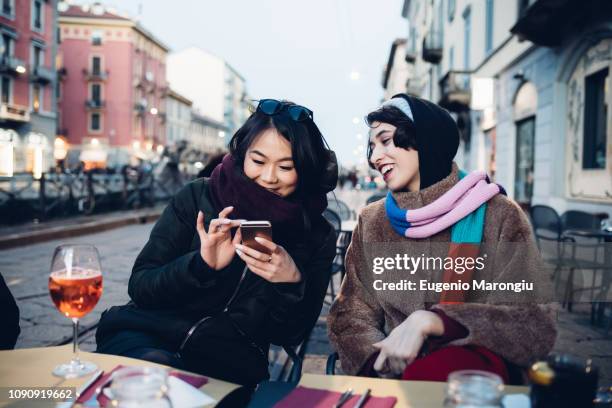 friends enjoying drink at outdoor cafe, milan, italy - italy beer stock-fotos und bilder