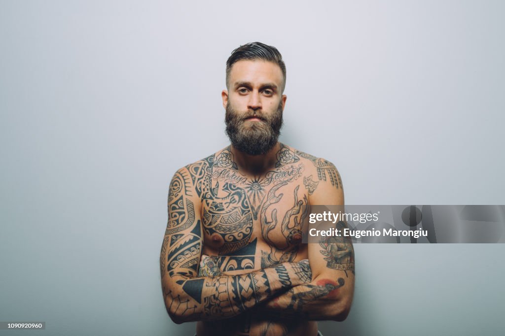 Portrait Of Young Man With Beard Bare Chest Covered In Tattoos Arms Folded  High-Res Stock Photo - Getty Images
