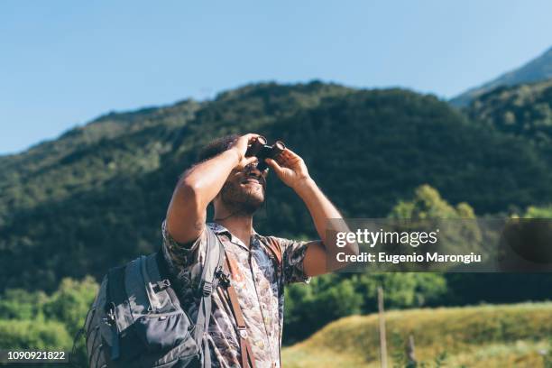 young male hiker looking up through binoculars, primaluna, trentino-alto adige, italy - bird watching stock pictures, royalty-free photos & images