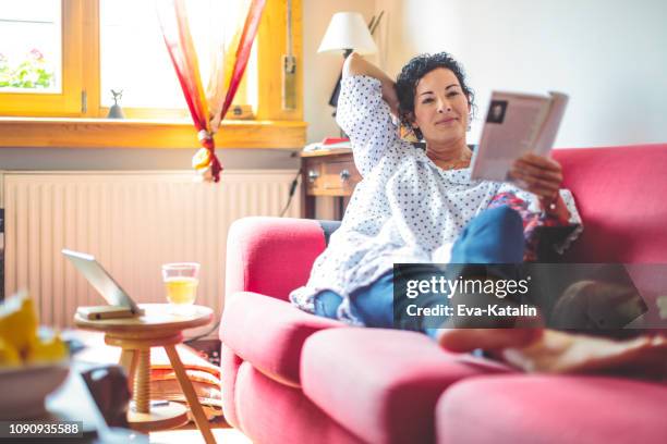 mid adult woman at home - reading magazine stock pictures, royalty-free photos & images