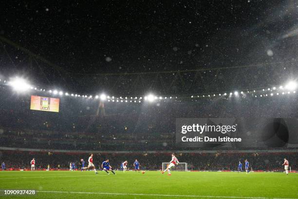 General view inside the stadium as snow falls during the Premier League match between Arsenal and Cardiff City at Emirates Stadium on January 29,...