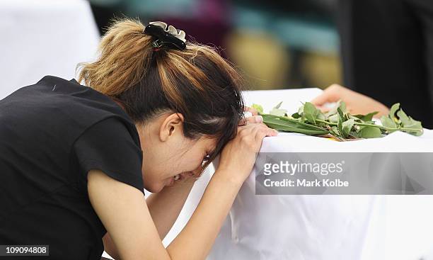 Mourner cries at the grave side at a Christian funeral service for the victims of the Christmas Island asylum seeker boat wreck at Castlebrook...