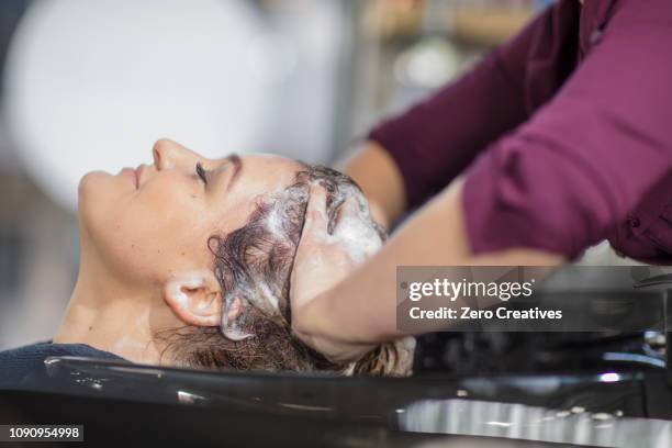 hairdresser shampooing customer's hair in salon - best beauty salon stock pictures, royalty-free photos & images