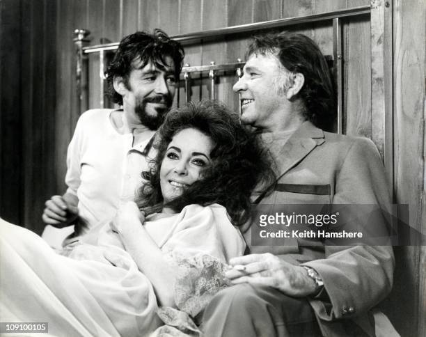 Richard Burton surprises co-stars Elizabeth Taylor and Peter O'Toole by joining them in bed for a photo opportunity, during the filming of a love...