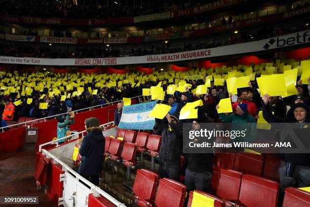 Cardiff City fans hold up Yellow cards in support of missing player Emiliano Sala during the Premier League match between Arsenal FC and Cardiff City...