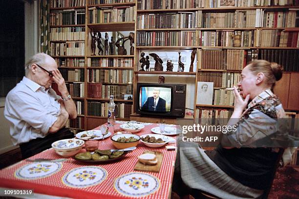 Moscow residents Yuri and Elena Pudalovi watch during dinner the televised address of Russian President Boris Yeltsin on March 20, 1993 in Moscow....