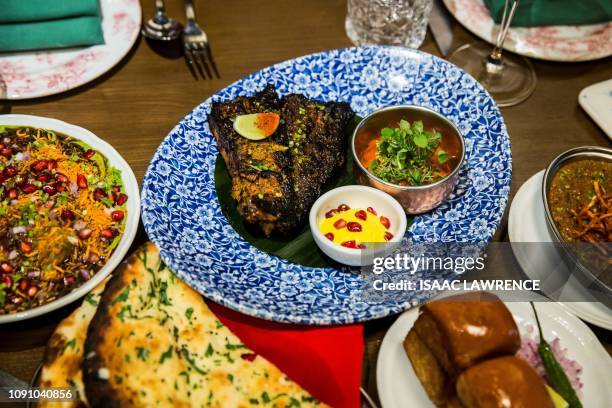 This picture taken on January 16, 2019 shows spiced fish , naan bread and other dishes on display at the New Punjab Club restaurant in Hong Kong. - A...