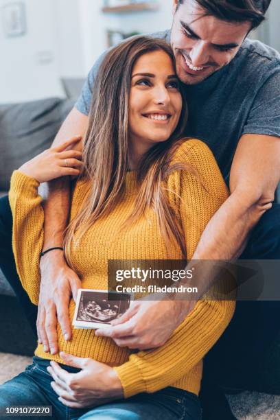 couple with baby ultrasound photo - pregnant couple stock pictures, royalty-free photos & images