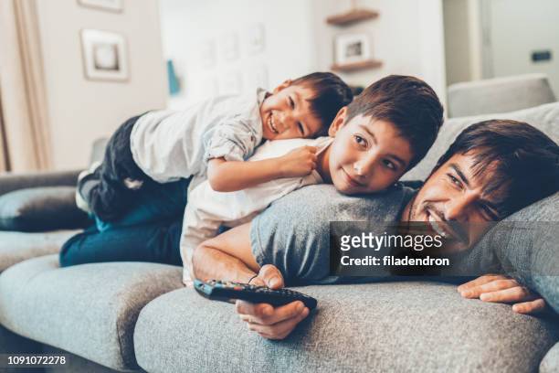 tiempo de padre e hijos - familia viendo television fotografías e imágenes de stock