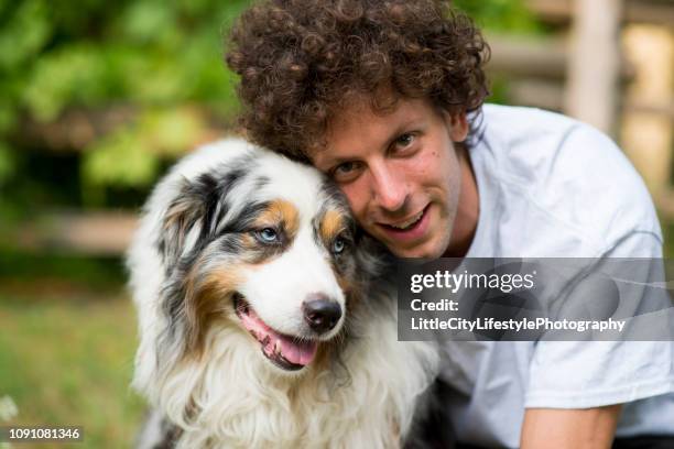 smiles from boy and dog - australian shepherd stock pictures, royalty-free photos & images