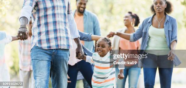 little african-american boy walking with large family - black family reunion stock pictures, royalty-free photos & images
