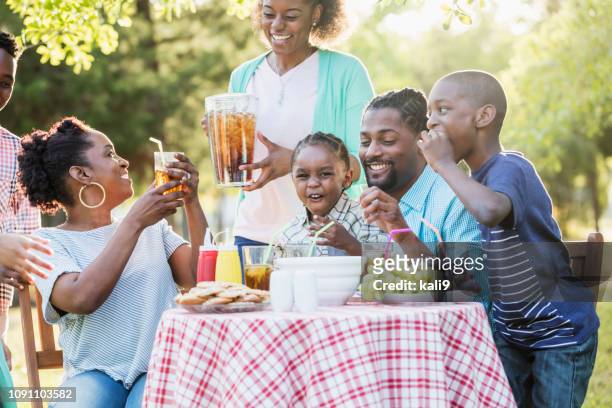 large african-american family having backyard cookout - black family reunion stock pictures, royalty-free photos & images