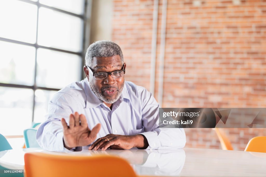 Senior African-American businessman, talking to viewer