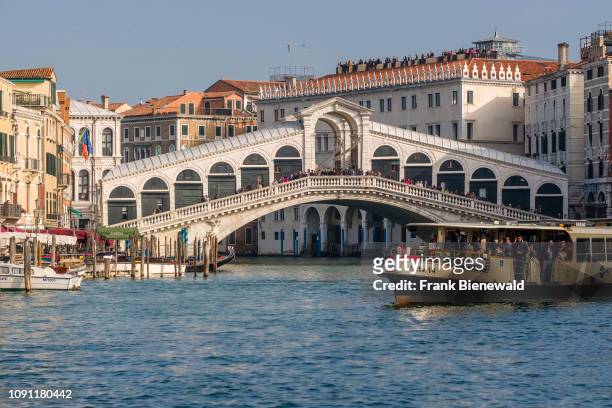 Rialto Bridge, Ponte di Rialto, a stone arch bridge, spanning the Grand Canal, Canal Grande, a local ferryboat crossing.