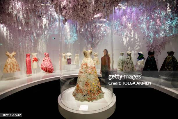 Assistants pose by a Jardin Fleuri bustier dress by Maria Grazia Chiuri on show at 'Christian Dior: Designer of Dreams' exhibition at the Victoria...